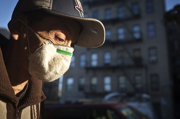 Человек в маске на фоне, где живет ребенок, госпитализированный с подозрением на лихорадку Эбола