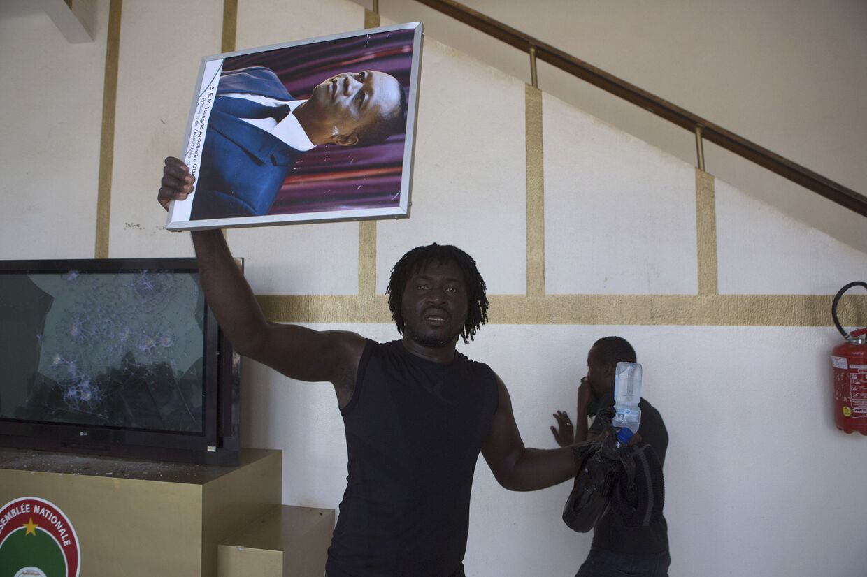 Протестующий с портретом Блэза Компаора в здании парламента 