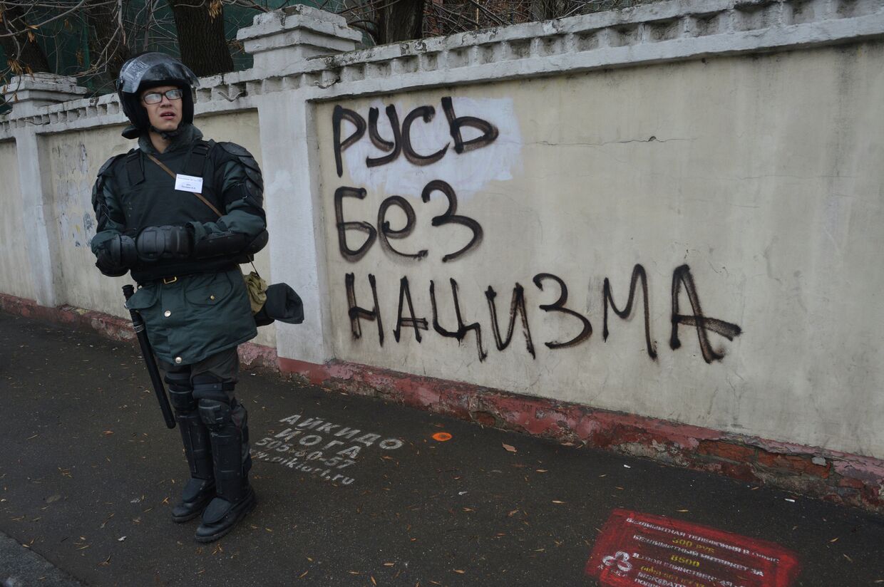 Сотрудник правоохранительных органов стоит в усилении во время проведения Русского марша в Москве.