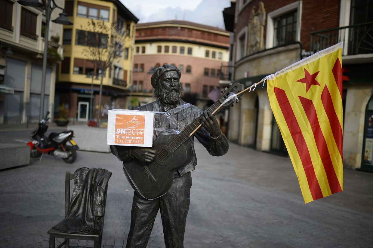Статуя баскского поэта и певца Хосе Марии Ипаррагирре с каталонским флагом и урной для голосования