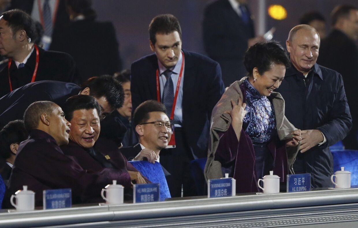 Владимир Путин накидывает плед на плечи первой леди Китая Пэн Лиюань