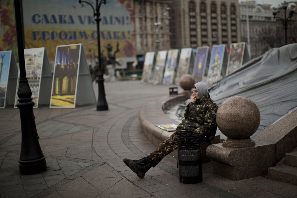 Молодой человек курит сигарету на Площади независимости в Киеве