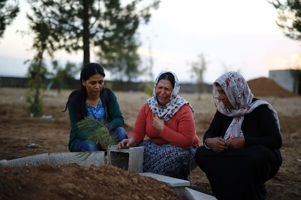 Женщины у могил курдских ополченцев, воевавших с боевиками Исламского государства в Кобани