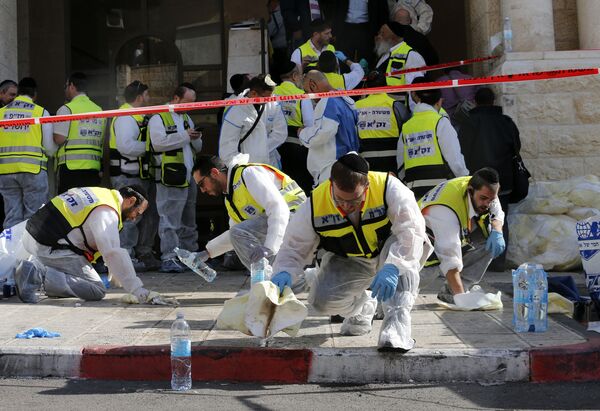 Сотрудники службы скорой помощи отмывают кровь с места теракта