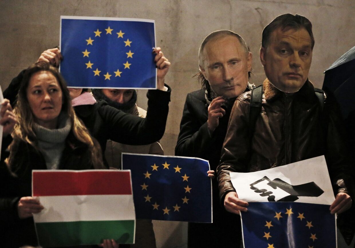 Демонстранты с потретами Владимира Путина и Виктора Орбана на акции протеста в Лондоне