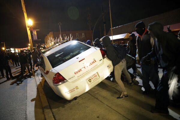 Протестующие переворачивают автомобиль полиции