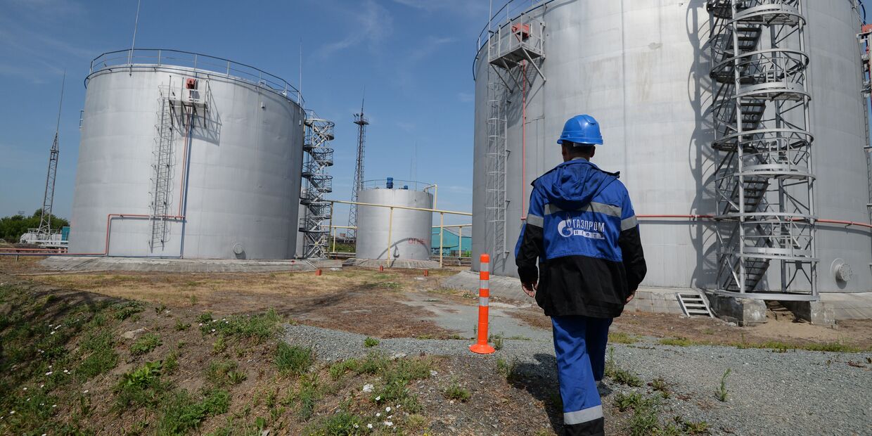 Сотрудник Новосибирской нефтебазы компании «Газпром нефть» возле резервуаров для хранения топлива