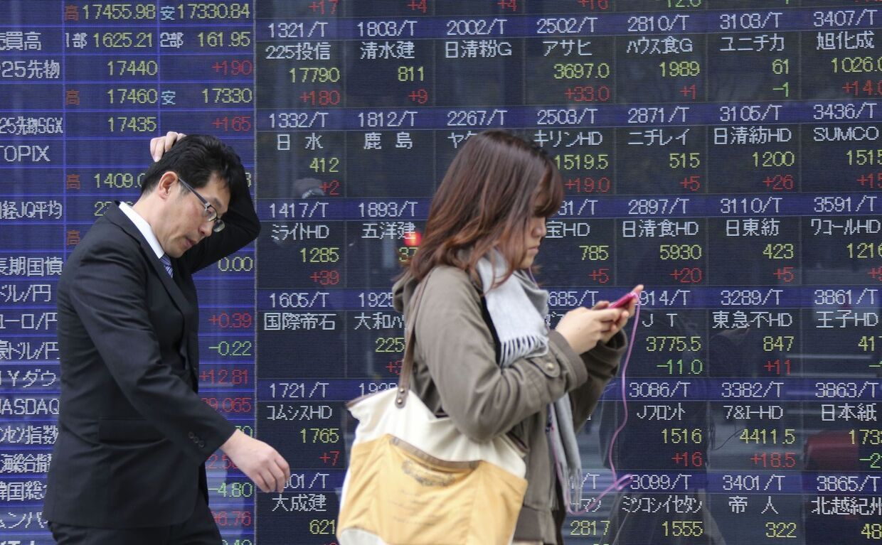 Табло с фондовыми индексами рынка акций в Токио