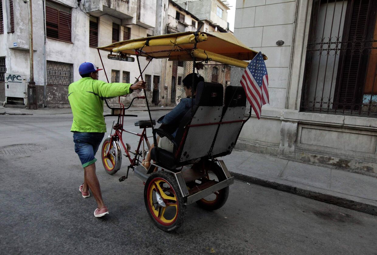 Велорикша с флагом США на улицах в Гаваны