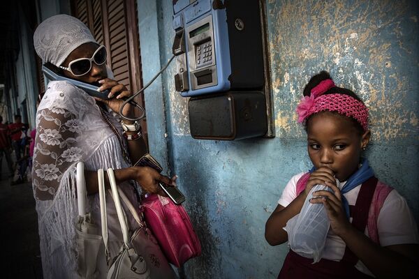 Девушка на улице Гаваны звонит из телефона-автомата 