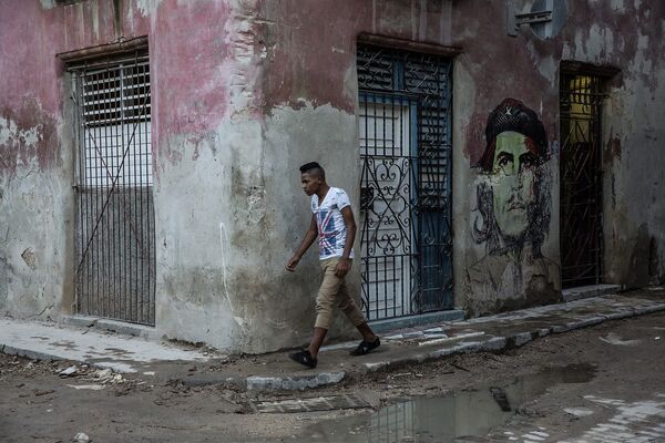 Юноша проходит мимо граффити с изображением Че Гевары