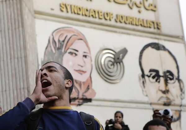 Акция протеста в Каире, на стене – портреты журналистов Майады Ашраф и Аль-Хусейни Абу Даифа