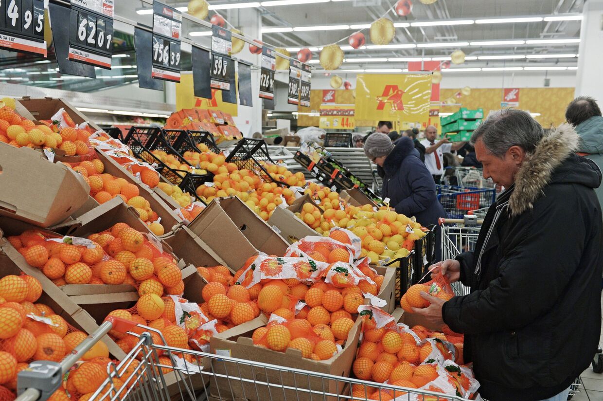 Посетитель выбирает фрукты в одном из магазинов торговой сети «Ашан» в Москве