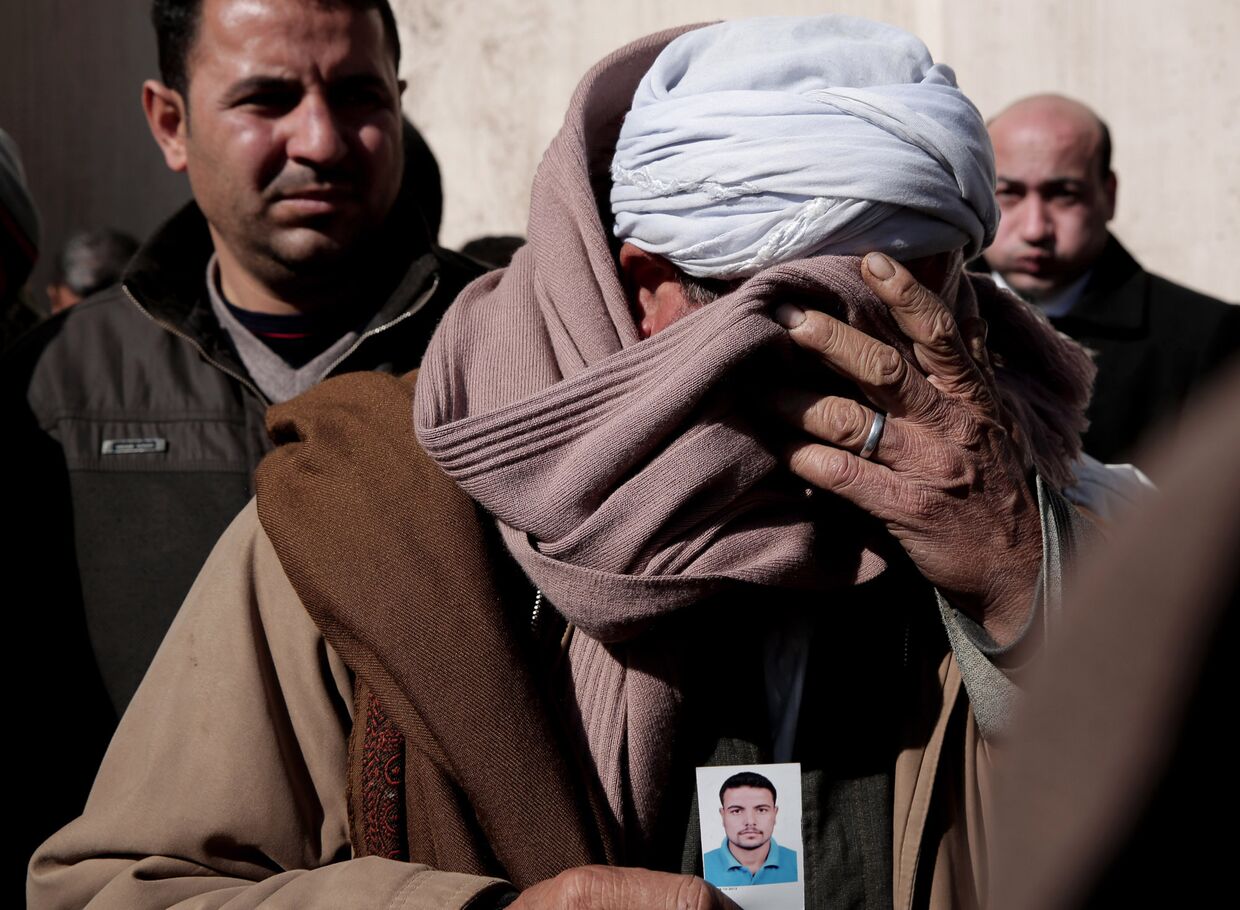 Христианин-копт Самир Муджид с фотографией своего сына Гиргиса, погибшего в Ливии