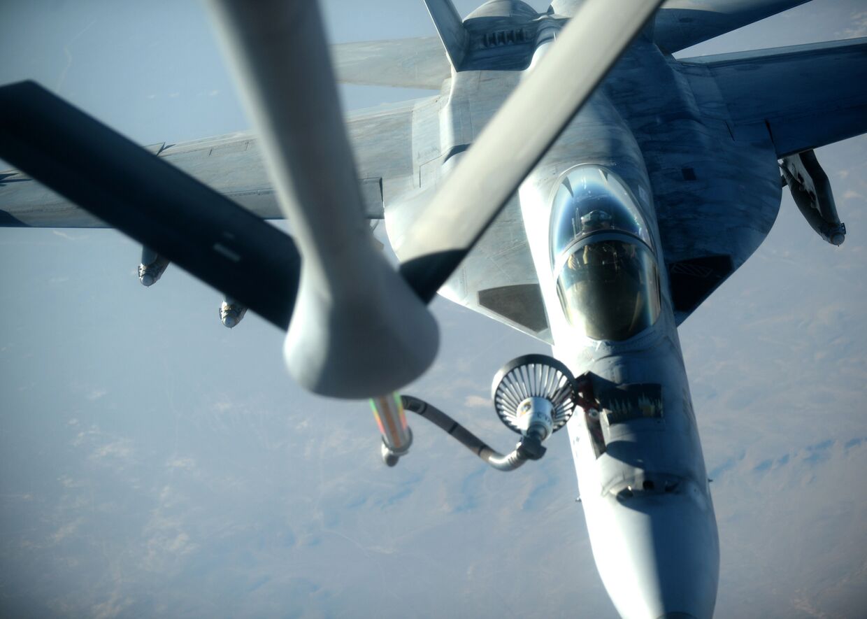 Истребитель F-18E Super Hornet заправляется от самолета-заправщика KC-135 Stratotanker после нанесения авиаудара по силам Исламского государства