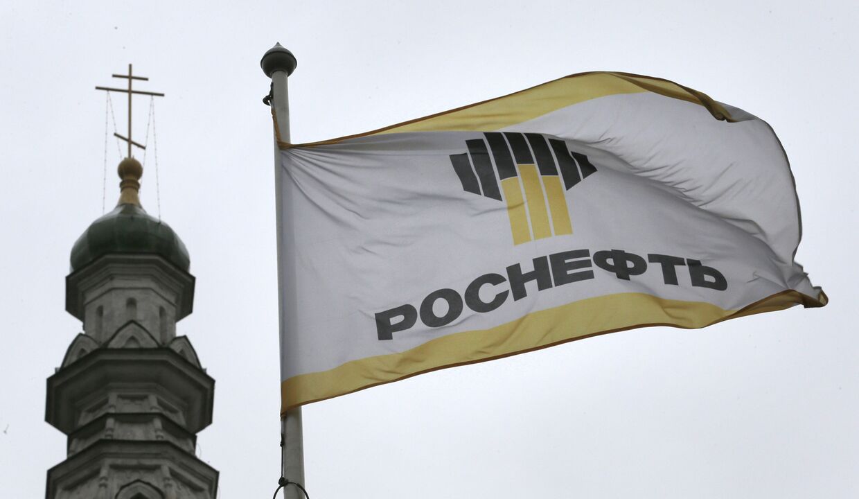 Флаг с логотипом компании «Роснефть» на фоне церкви в Москве
