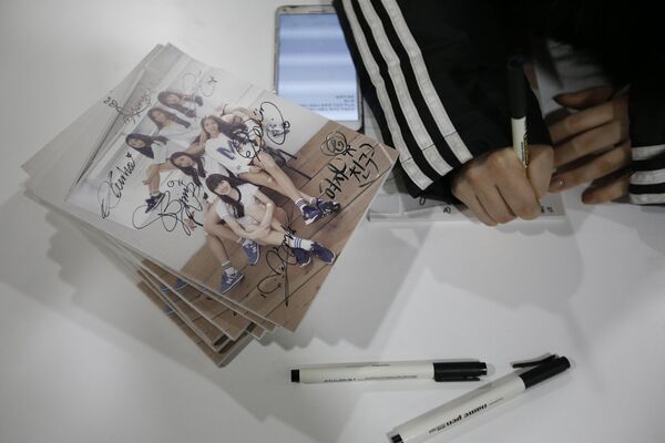 Участницы группы GFriend подписывают свои альбомы