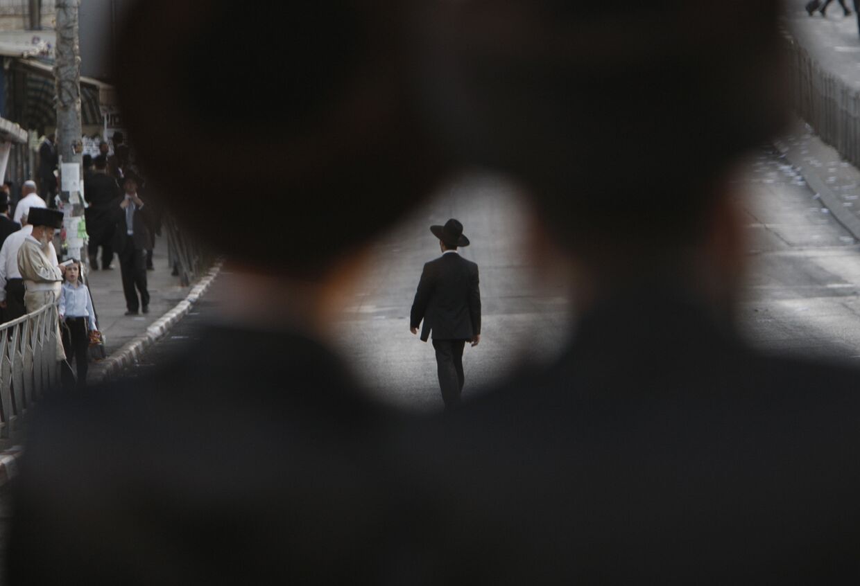 Ультраортодоксальный еврей идет по пустой улице в Иерусалиме