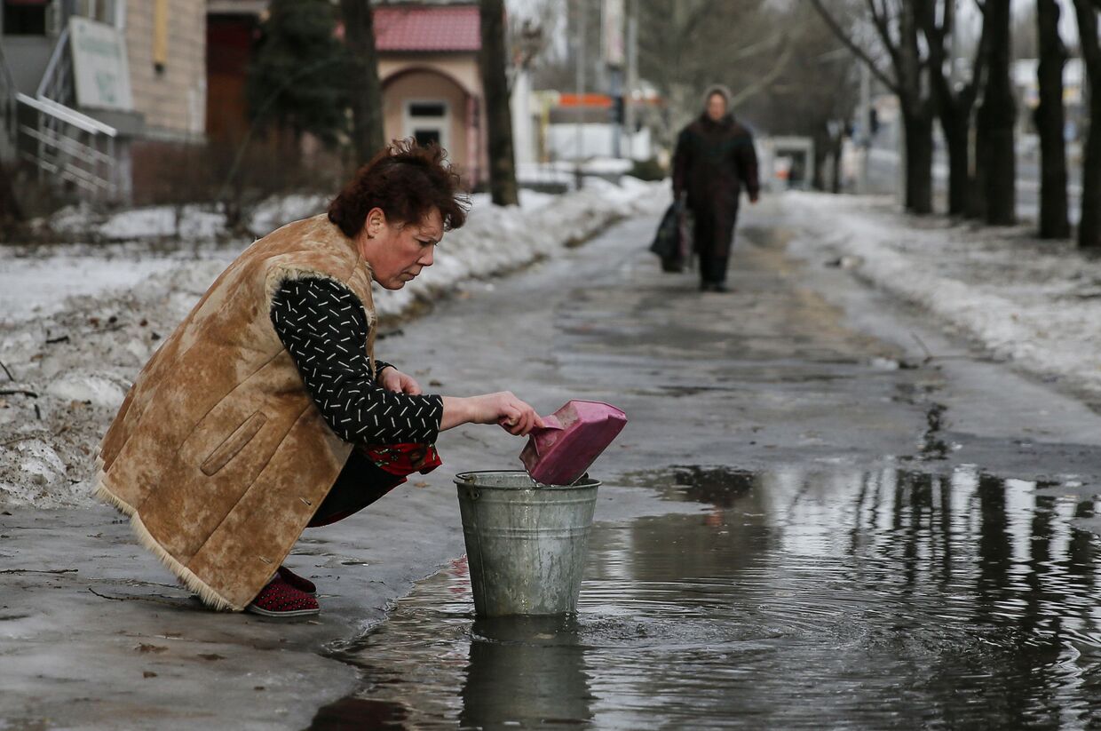 Женщина в Донецке набирает воду из лужи