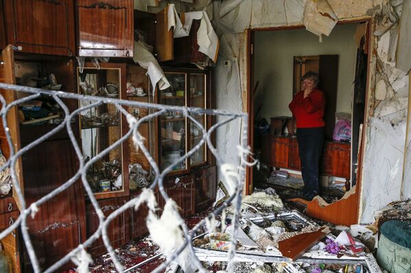 Женщина в своей квартире, пострадавшей от обстрела, Енакиево, Донецкая область