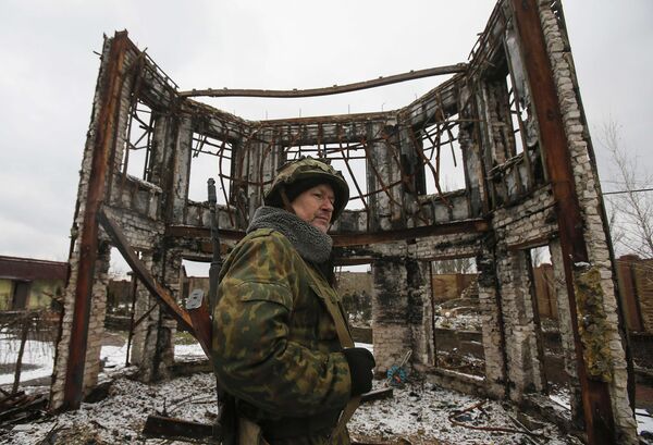 Ополченец рядом с разрушенным зданием в Углегорске