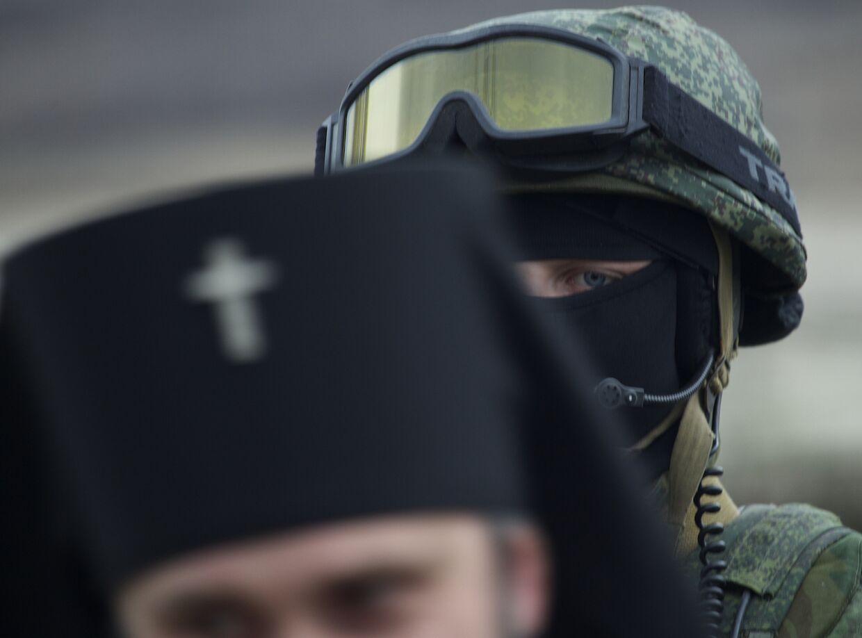 Российский солдат и украинский священник рядом с военной базой в Симферополе, 2 марта 2014 года