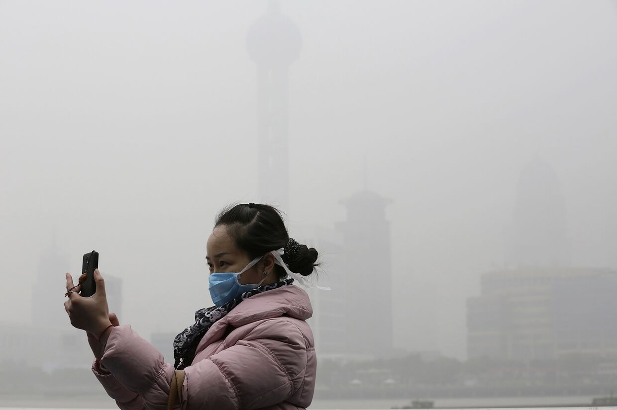 Девушка делает селфи во время сильного смога в Шанхае