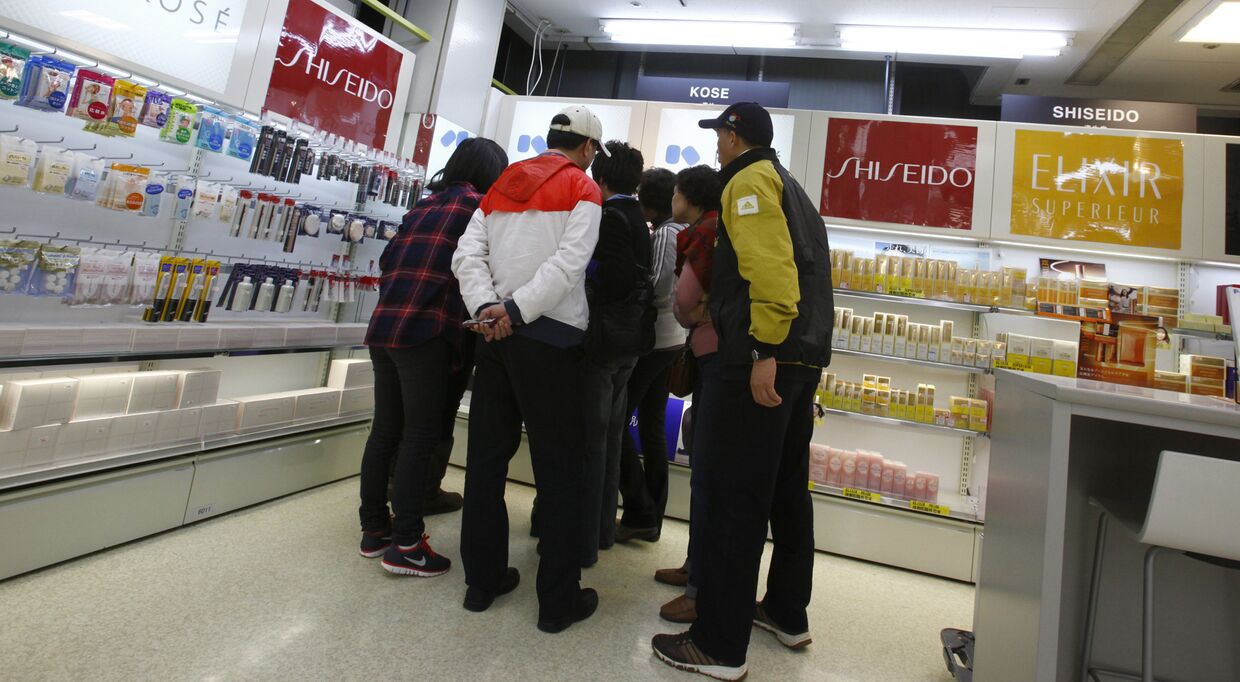 Китайские туристы разглядывают японскую косметику в магазине в Токио