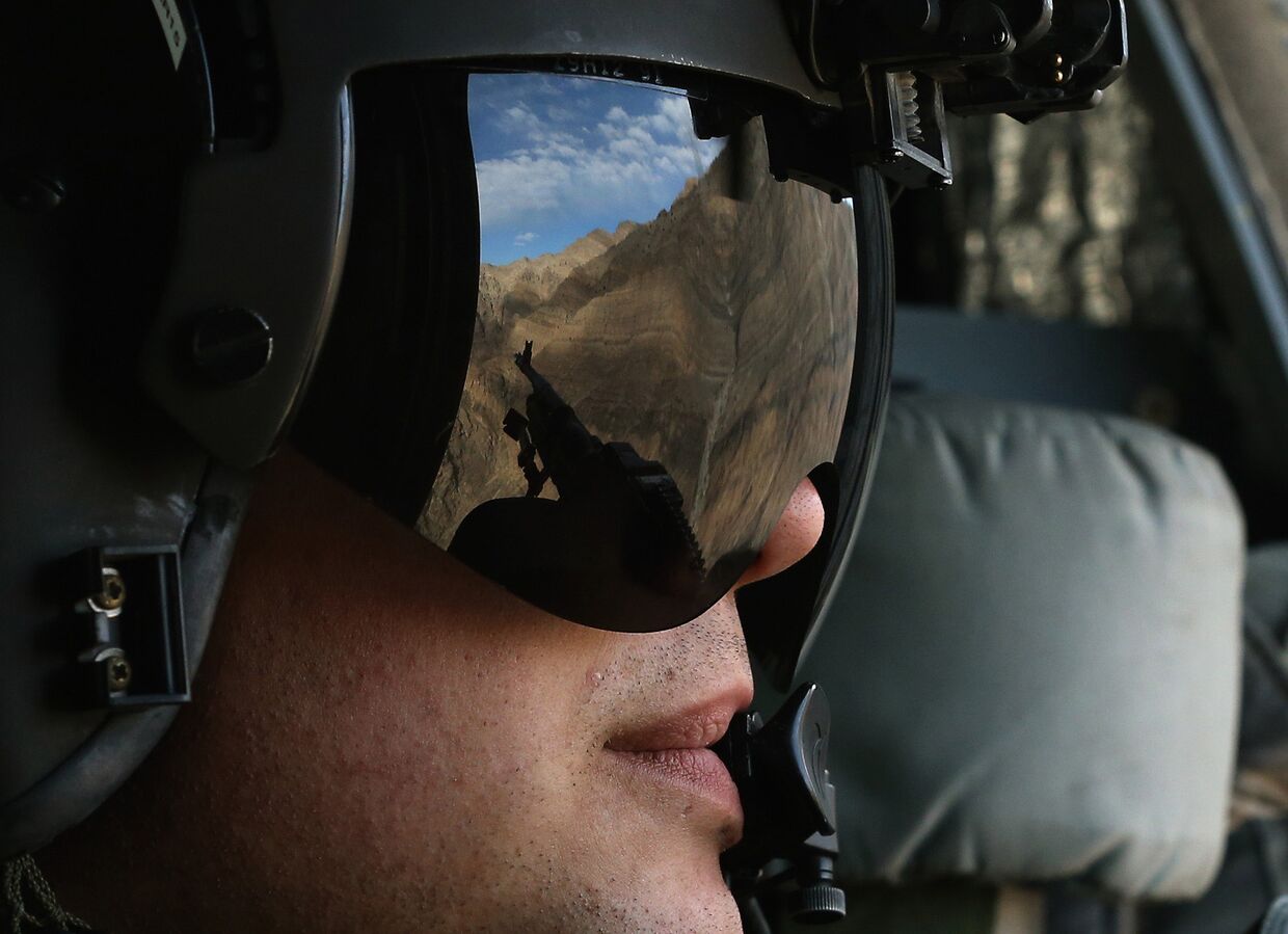 Солдат америкаснкой армии сопровождает Чака Хейгела на вертолете во время его визита в восточный Афганистан