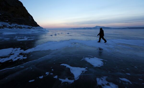 Рыбак идет по замерзшей поверхности реки Енисей рядом с поселком Анаш в Красноярском крае