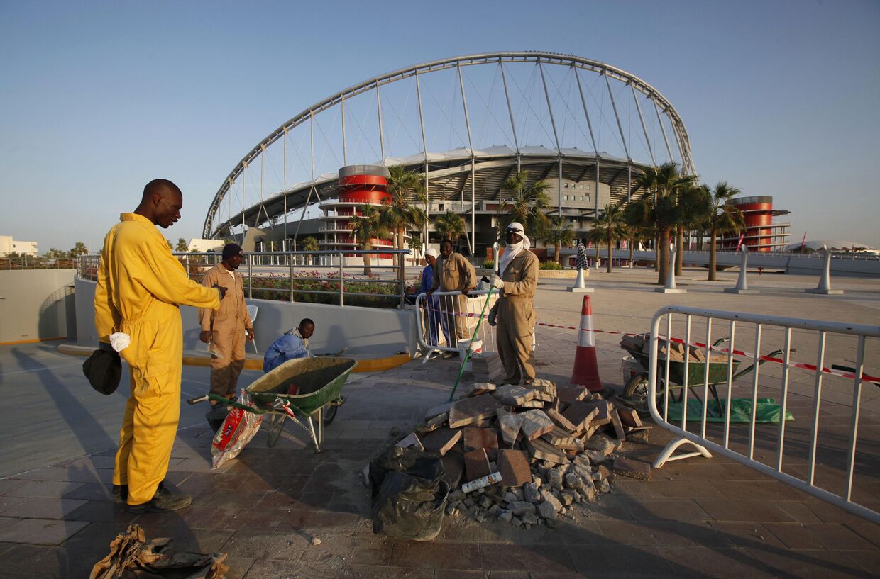 Рабочие рядом со стадионом «Халифа» в Дохе