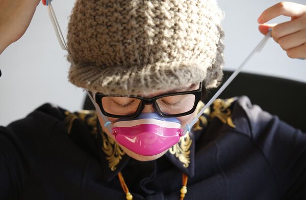 Вонг Сяоянь надевает маску для носа 