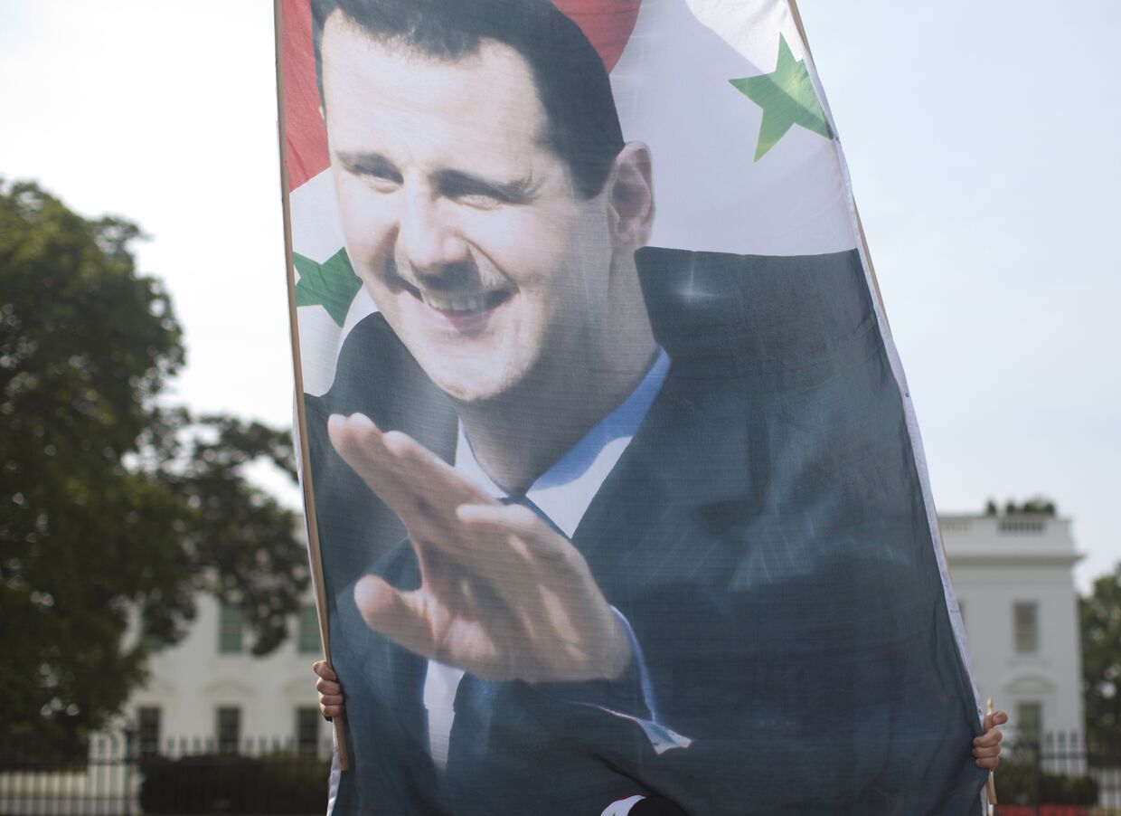 Плакат с президентом Сирии Башаром Асадом на демонстрации у Белого дома, 9 сентября 2013 года
