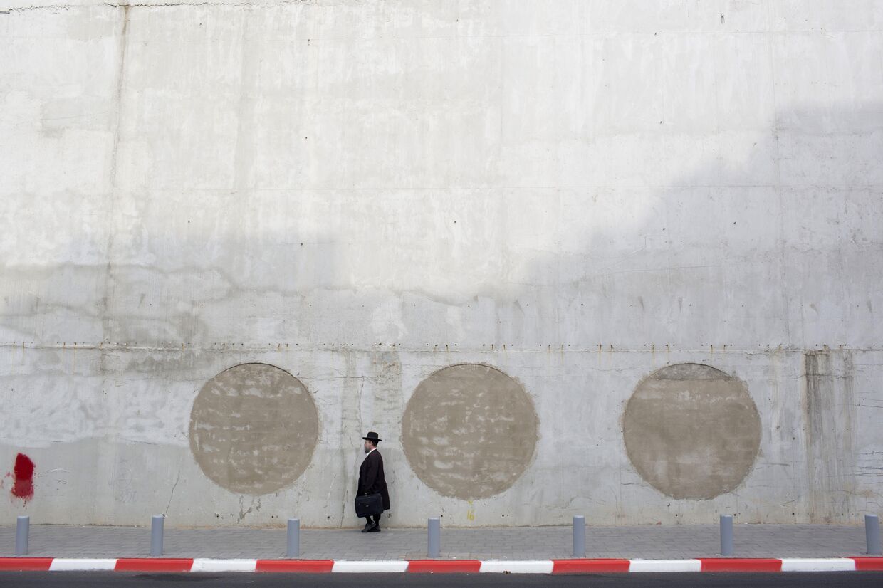Ультраортодоксальный еврей рядом с недостроенным зданием в городе Рамат-Ган