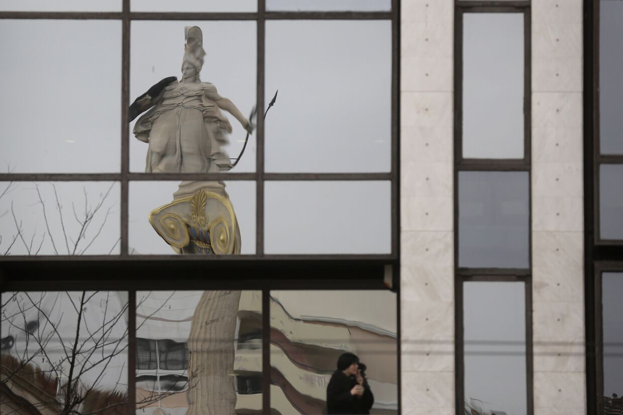 Статуя богини Афины отражается в здании 