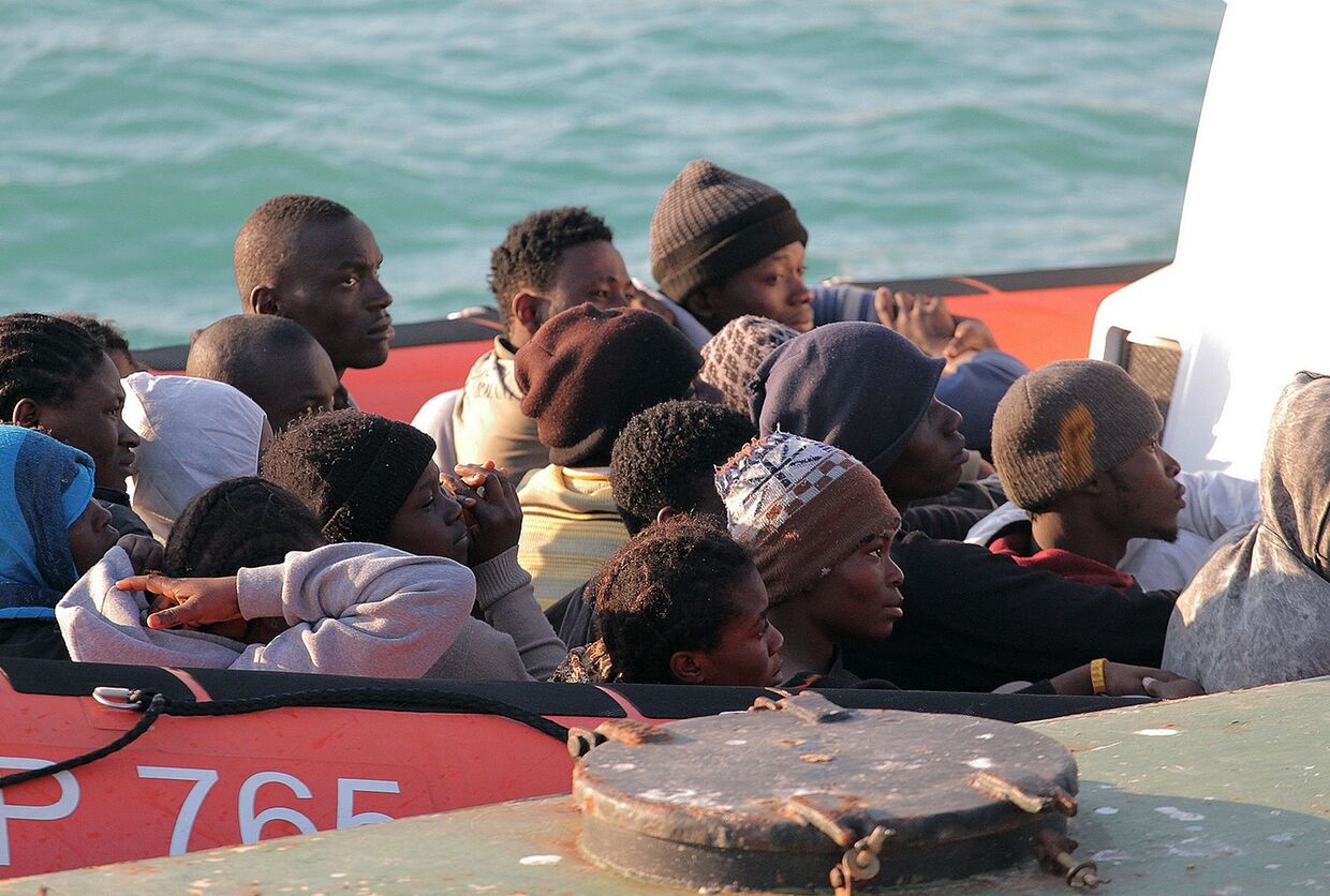 Мигрантов, чья лодка перевернулась у берегов Ливии, доставляют в Порт-Эмпедокле на Сицилии