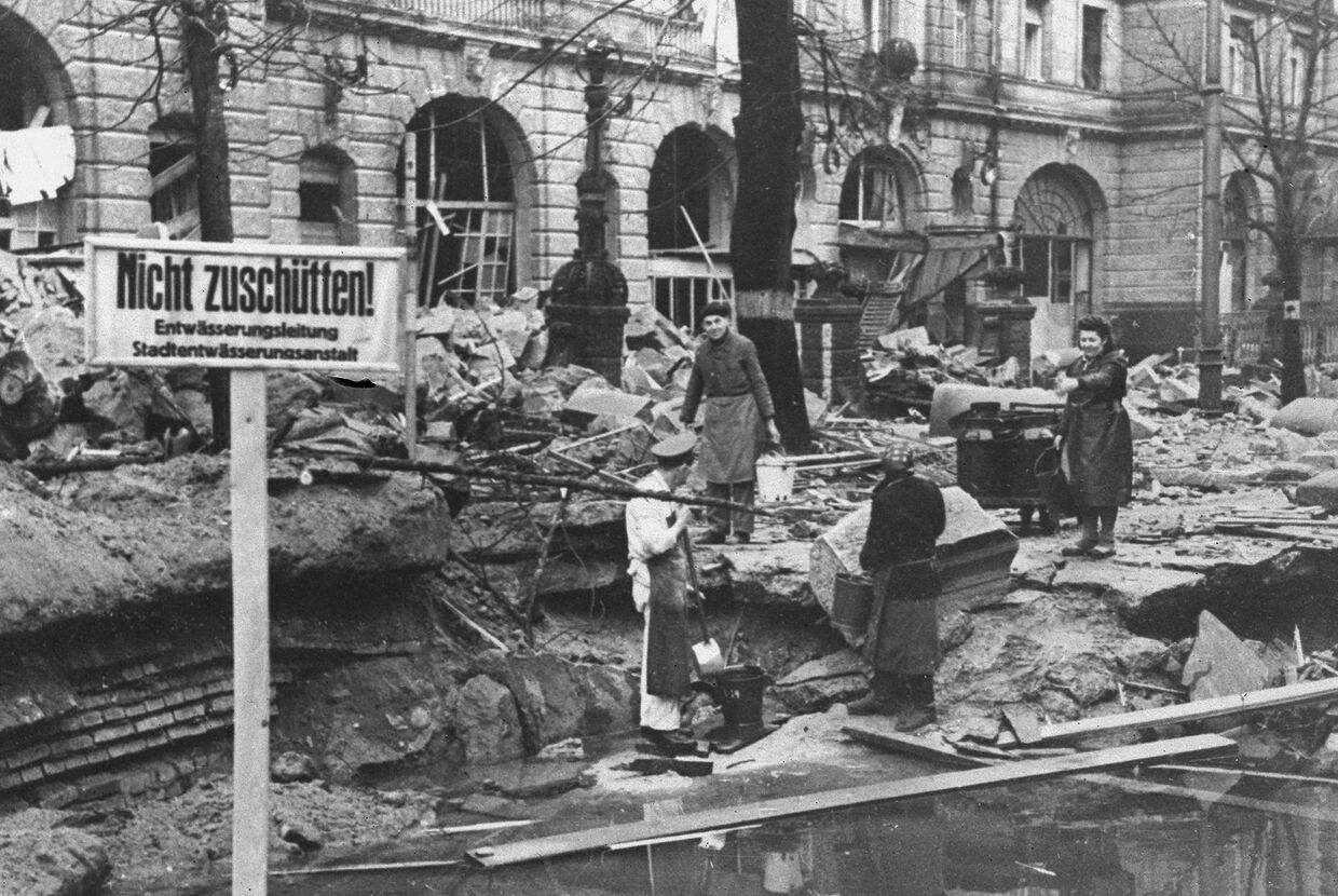 Берлинцы набирают воду на улице полуразрушенного города, апрель 1945 года