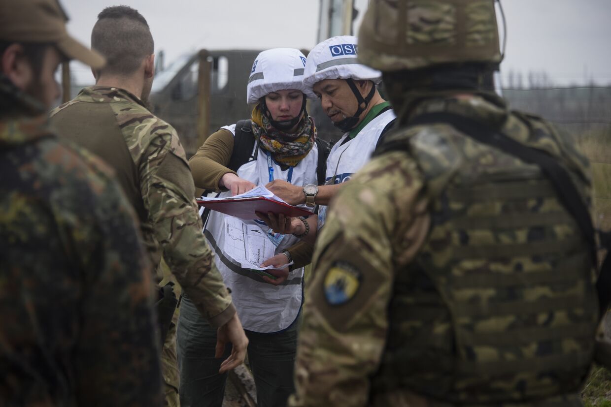 Наблюдатели ОБСЕ разговаривают с украинскими военными рядом с деревней Широкино