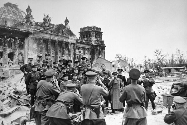Военные корреспонденты фотографируются у стен разрушенного рейхстага
