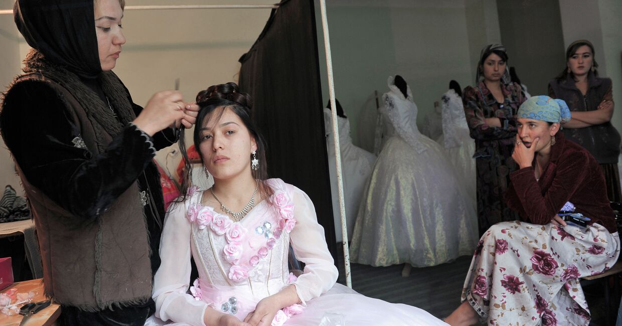 Парикмахер делает невесте прическу в свадебном салоне города Душанбе в Таджикистане