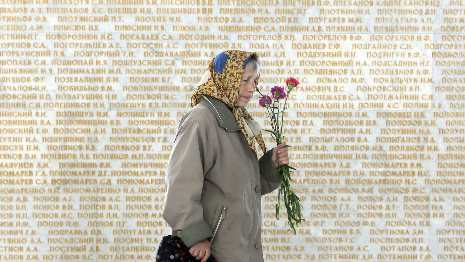 Женщина на фоне стены с именами погибших в Великой отечественной войне в Киеве - ИноСМИ, 1920, 09.05.2024