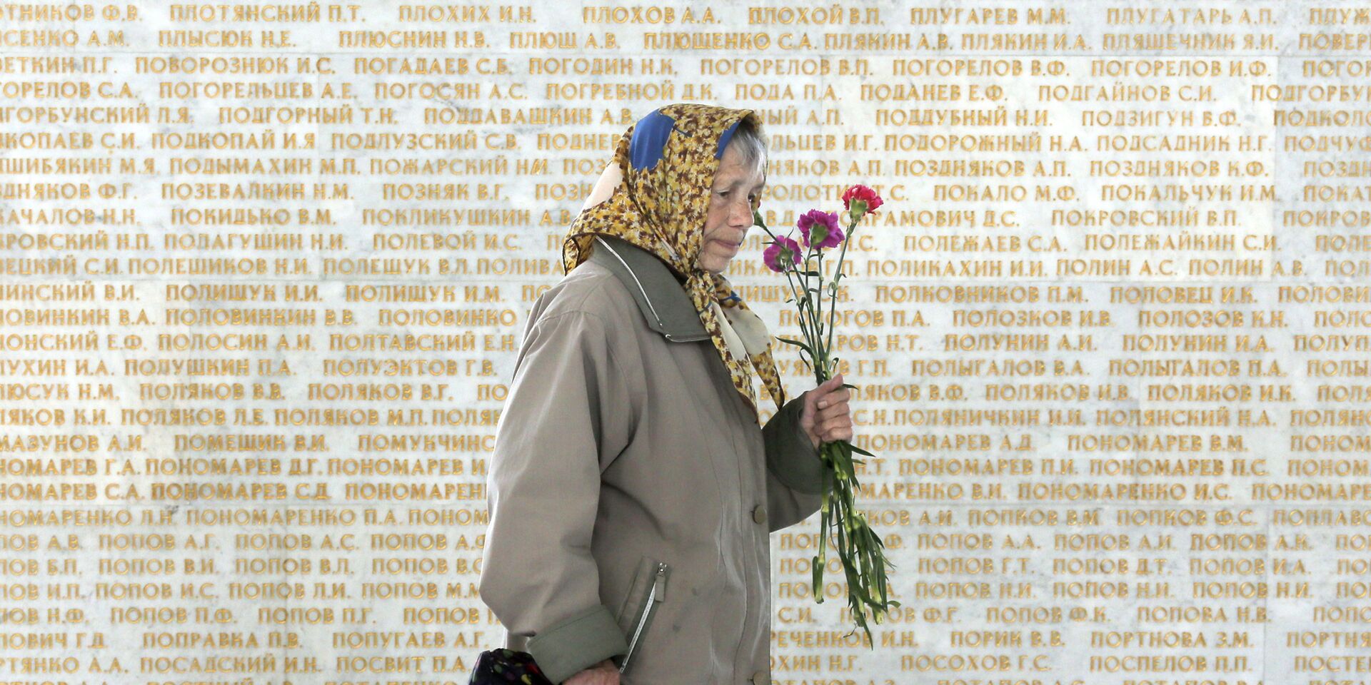 Женщина на фоне стены с именами погибших в Великой отечественной войне в Киеве - ИноСМИ, 1920, 14.02.2023