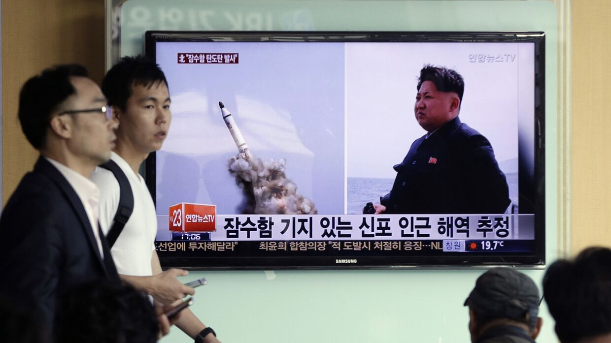 Телевидение в Сеуле демонстрирует кадры, на которых изображены Ким Чен Ын и ракета, предположительно запущенная в КНДР с подводной лодки