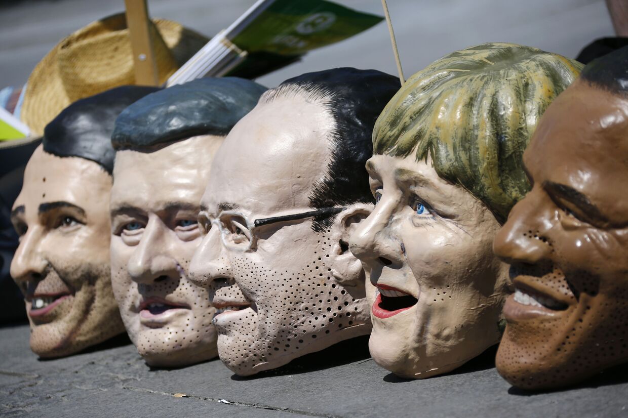 Маски с лицами участников саммита G7 во время акции протеста в Мюнхене