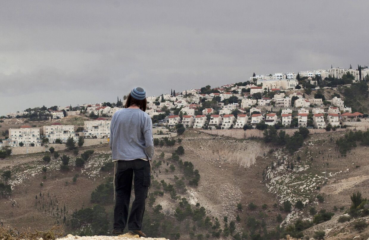 Израильтянин смотрит на город Маале-Адумим на Западном берегу реки Иордан