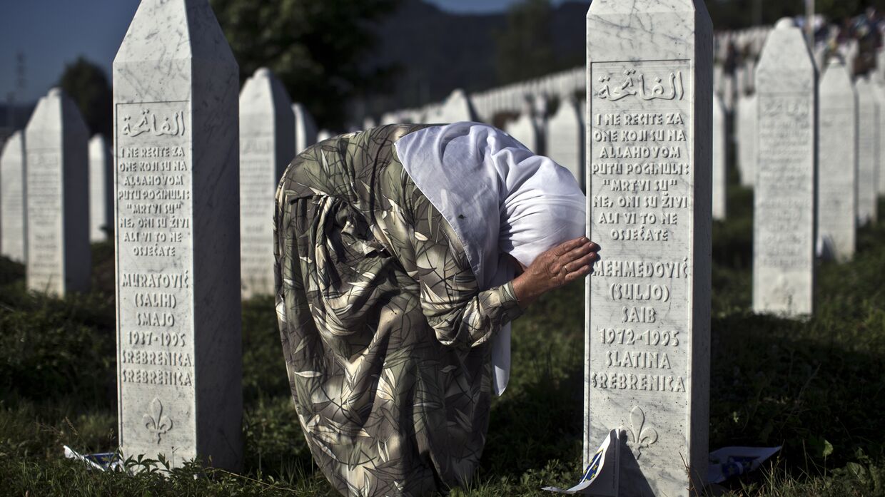 Женщина у могилы родственника в мемориальном комплексе Поточари под Сребреницей