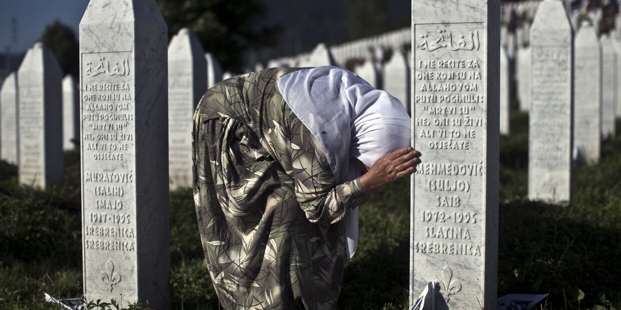 Женщина у могилы родственника в мемориальном комплексе Поточари под Сребреницей