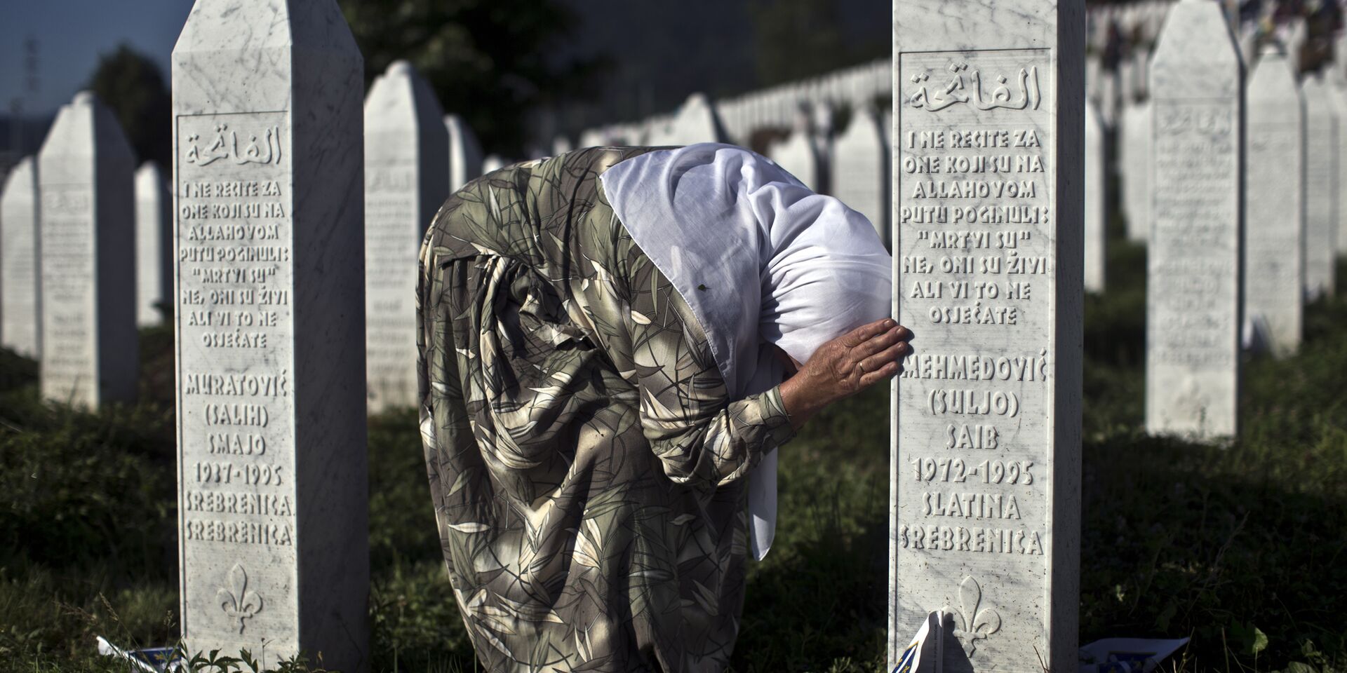 Женщина у могилы родственника в мемориальном комплексе Поточари под Сребреницей - ИноСМИ, 1920, 18.08.2023