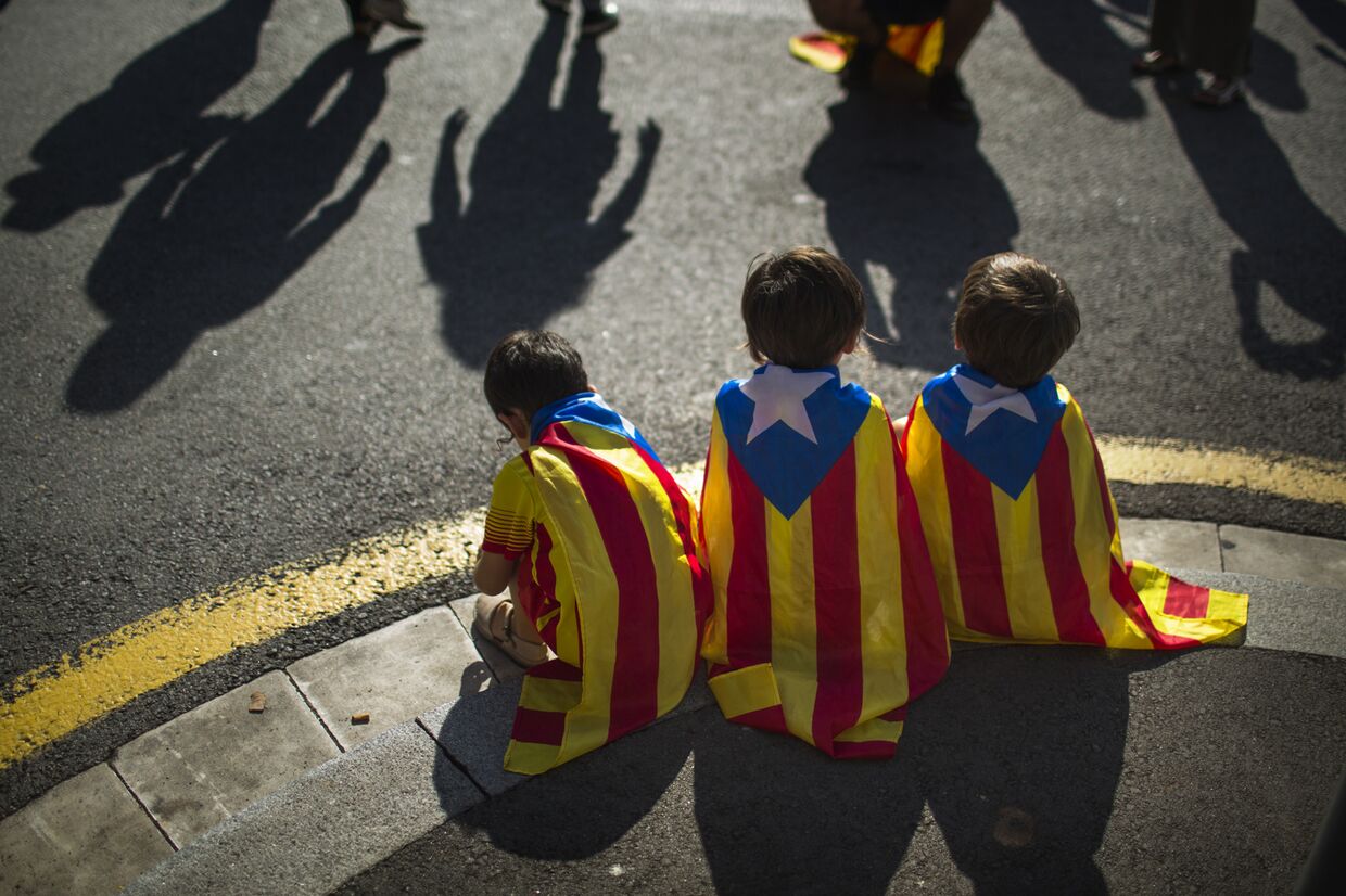 Дети с флагами Каталонии на митинге сторонников независимости в Барселоне