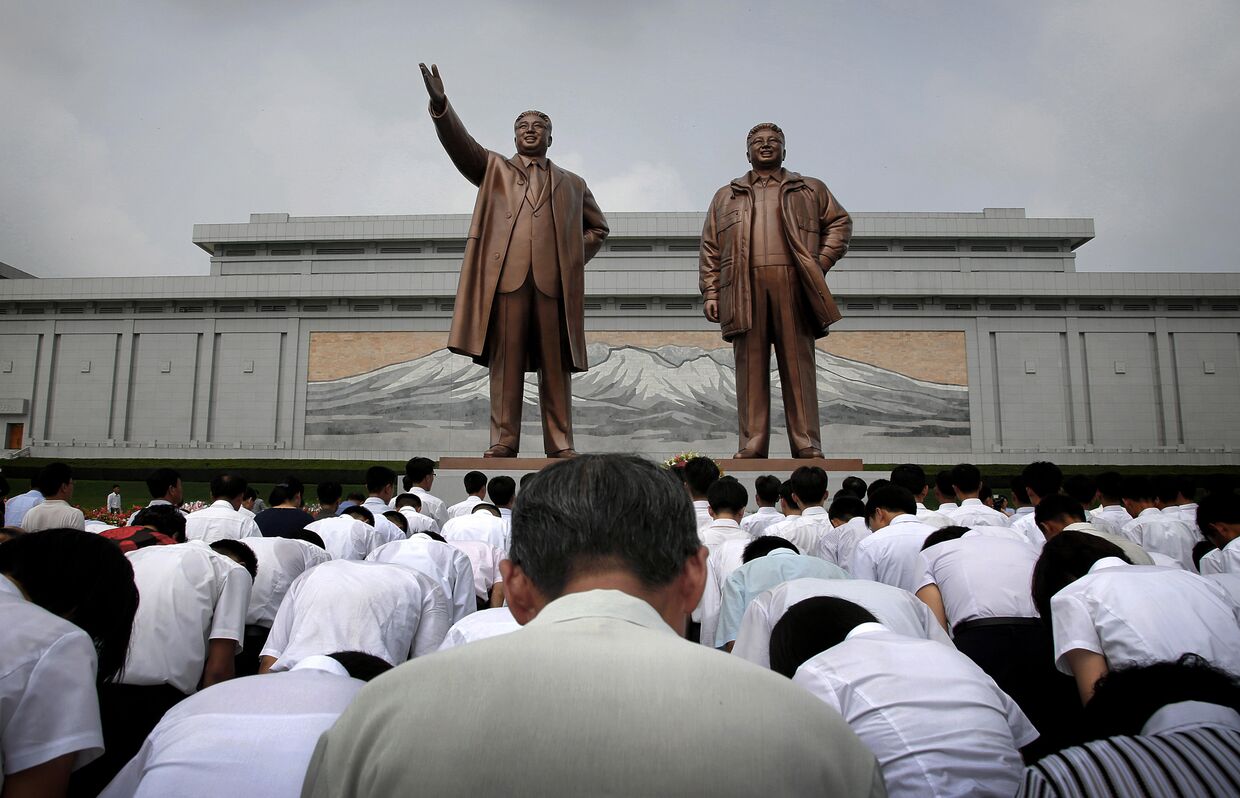 Корейцы у памятников Ким Ир Сена и Ким Чен Иру во время празднования 62-летия окончания Корейской войны